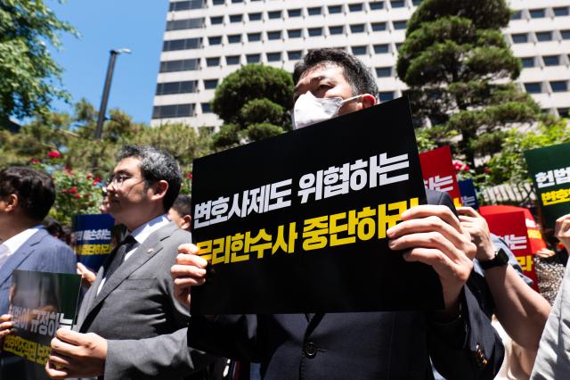 A lawyer holds a placard reading Stop the Excessive Investigation Threatening the Lawyer System during a rally organized by the Korean Bar Association in front of the Seoul Metropolitan Police Agency in Jongno-gu Seoul on June 3 2024 AJU PRESS Park Jong-hyeok