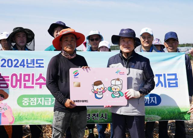 농촌 일손돕기에 나선 최기문 영천시장오른쪽이 농민들과 함께 농어민수당 지급 전용카드 모형을 들고 기념 촬영 하고 있다사진영천시