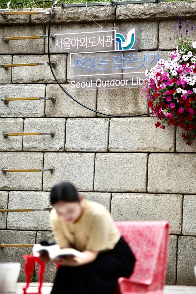 Visitor reads at the outdoor library at Cheonggyecheon in Jongno on June 7 2024 AJUPRESS Han Jun-gu