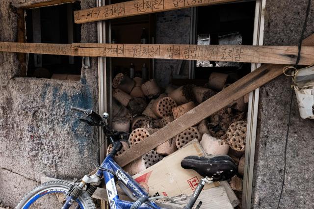 Used briquettes are stacked chest-high inside a vacant home With redevelopment set for completion by next year over half of the houses in the shantytown now stand empty AJU PRESS Park Jong-hyeok