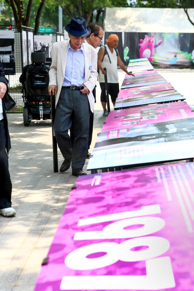 Peoples watch a photo exhibition held on the sidelines of the 6·10 commemoration ceremony at Seoul City Hall in central Seoul on June 10 2024 AJU PRESS Kim Dong-woo