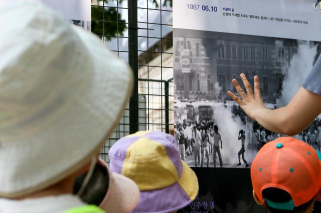 Peoples watch a photo exhibition held on the sidelines of the 6·10 commemoration ceremony at Seoul City Hall in central Seoul on June 10 2024 AJU PRESS Kim Dong-woo