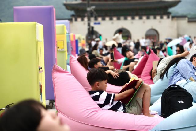 A child reads a book during the Seoul Outdoor Library event at Gwanghwamun Square in Seoul on June 7 2024 AJU PRESS Han Jun-gu