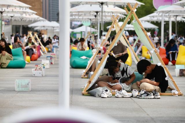 Visitors read and relax during the Seoul Outdoor Library event at Gwanghwamun Square in Seoul on June 7 2024 AJU PRESS Han Jun-gu