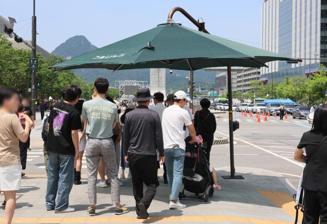 최근 서울 종로구 광화문 네거리에 설치된 그늘막 아래 시민들이 모여있다 사진연합뉴스
