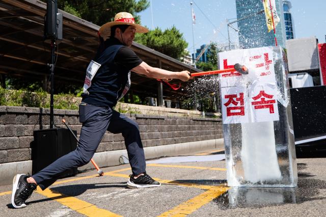 Choi Young-chan the chairman of the Korean Democratic Street Vendors Confederation performs the symbolic act of breaking ice with the words crackdown on street vendors in front of the Korea Development Bank on Yeouido Yeongdeungpo district Seoul on June 13 2024 AJU PRESS Park Jong-hyeok