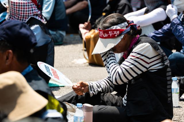 A participant at the 613 National Street Vendors Rally wipes sweat from their face due to the heat in front of the Korea Development Bank in Yeongdeungpo district Seoul on June 13 2024 AJU PRESS Park Jong-hyeok