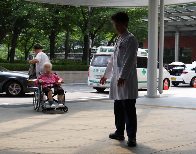 대한의사협회와 의사단체가 오는 18일부터 전면 휴진을 예고한 가운데 12일 오후 서울의 한 대학 병원에서 한 의사가 환자 앞을 지나고 있다 사진연합뉴스