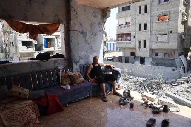 한 팔레스타인 남성이 파괴된 아파트에서 쪼개진 무기 잔해를 바라보는 모습 사진AFP 연합뉴스