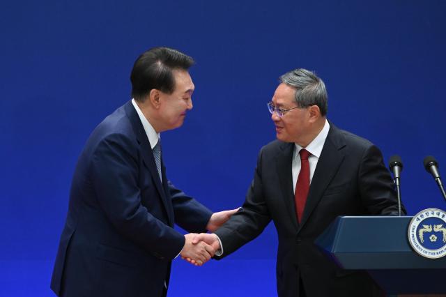 President Yoon Suk Yeol left shakes hands with Chinese Premier Li Qiang after a joint press conference event held in central Seoul on May 27 Yonhap Photo