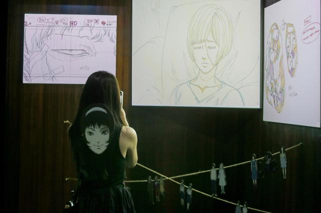 A visitor takes a photo of Junji Itos original artwork at an exhibition in Mapo-gu Seoul June 17 2024 AJU PRESS Kim Dong-woo