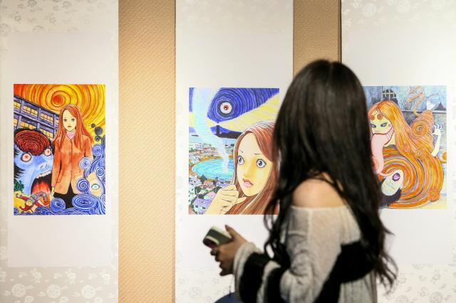A visitor walks past an exhibition of original paintings by Junji Ito at a gallery in Mapo-gu Seoul June 17 2024 AJU PRESS Kim Dong-woo