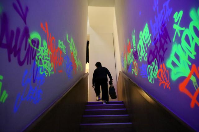 A visitor walks up graffiti-covered stairs at the REAL BANKSY Banksy is NOWHERE exhibition AJU PRESS Han Jun-gu