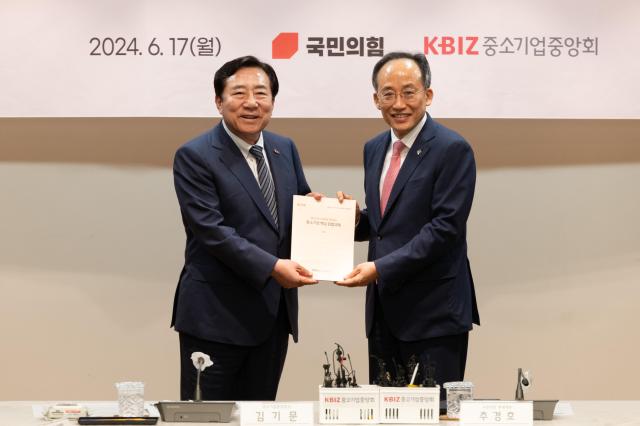 Korea Federation of SMEs Chairman Kim Ki-mun and People Power Party floor leader Choo Kyung-ho smile brightly while holding a document on its policy proposal at the K-BIZ building in Yeouido Seoul on June 17 2024 AJU PRESS Park Jong-hyeok