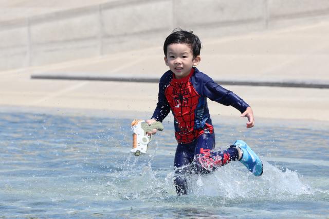 무더위가 이어진 18일 오후 서울 영등포구 여의도 물빛광장을 찾은 어린이가 물놀이하고 있다 사진연합뉴스