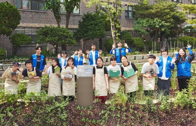 현대글로비스 임직원들이 서울 상원초학생들과 도심 생태숲을 조성하고 기념촬영을 하고 있다