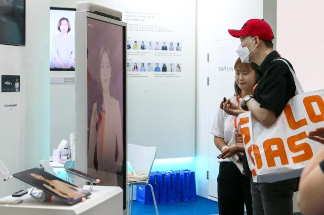 A visitor listens to a booth representative at Smart Tech Korea at COEX in Seoul on June 19 2024 AJU PRESS Kim Dong-woo