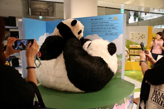 Visitors take pictures of a large figure at the Bao Family Pop-up Store Season 2 held at The Hyundai Seoul on June 20 2024 AJU PRESS Han Jun-gu
