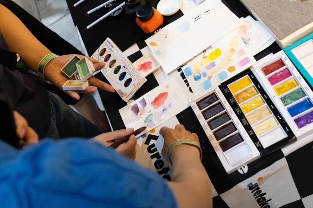 Visitors trying out Kuretake a Japanese brand paints and brush pens at The 6th Korea Minhwa Art Fair SETEC Gangnam Seoul June 20 2024 Various folk painting materials including Kuretake are sold at special prices during the fair AJU PRESS Park Jong-hyeok