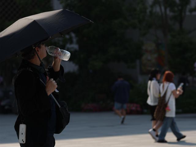 기상관측 이래 6월 중 가장 더운 날로 기록된 지난 19일 오후 서울 광화문광장을 찾은 한 외국인이 물을 마시는 모습 사진연합뉴스