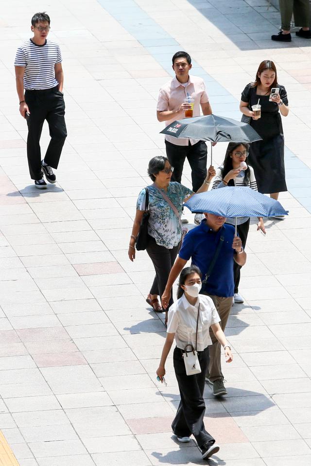 People walk while wearing a parasol in Yongsan-gu Seoul on June 20 2024 AJU PRESS Kim Dong-woo