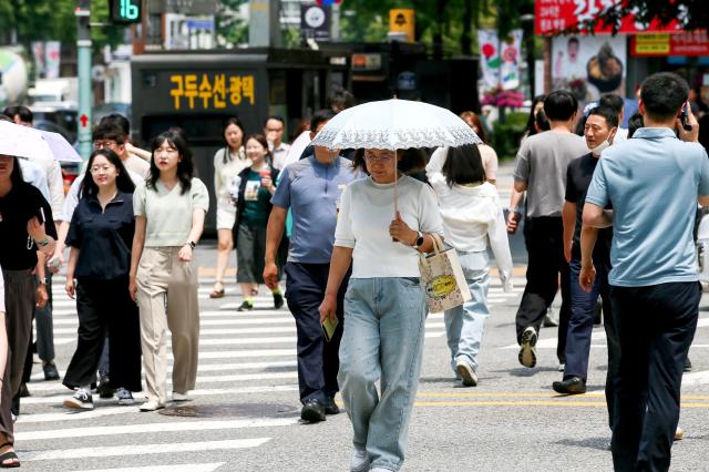 People walk while wearing a parasol in Yongsan-gu Seoul on June 20 2024 AJU PRESS Kim Dong-woo