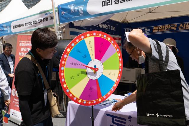 Attendee spins wheel at booth during Unification Culture Festival at Cheonggye Plaza Jongno-gu Seoul on June 21 2024 AJU PRESS Park Jong-hyeok