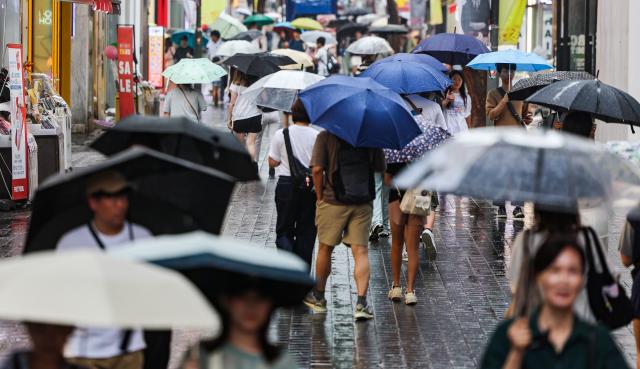 비가 내린 지난 22일 오전 서울 명동거리에 시민들과 관광객들이 우산을 쓰고 이동하고 있다 사진연합뉴스