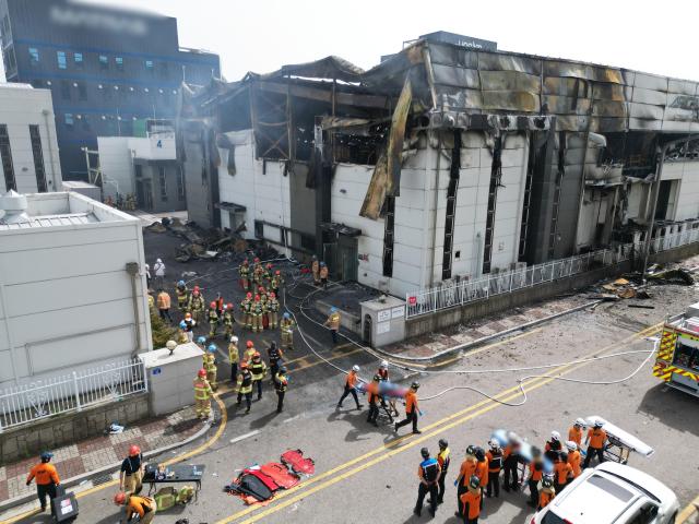 Firefighters retrieve the bodies of workers at the site of a fire at a primary lithium battery factory in Hwaseong south of Seoul on June 24 2024 Yonhap