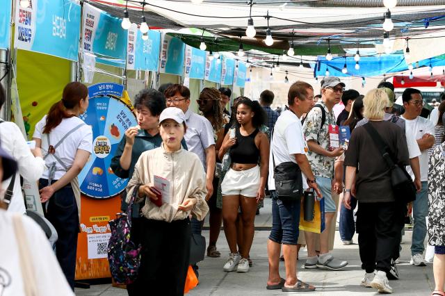 Visitors walk past the Newhwagae Market of the 2024 Young Ho Nam Win-Win Cooperation the Grand Festival of Harmony Gwanghwamun Square in Seoul on June 24 2024 AJU PRESS Kim Dong-woo