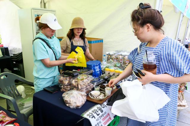 A visitor tastes at the 2024 Young Ho Nam Win-Win Cooperation the Grand Festival of Harmony Gwanghwamun Square in Seoul on June 24 2024 AJU PRESS Kim Dong-woo