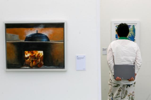 A visitor looks at a painting at the 2024 Young Ho Nam Win-Win Cooperation the Grand Festival of Harmony Young Ho Nam Young Artist Art Exhibition Gwanghwamun Square in Seoul on June 24 2024 AJU PRESS Kim Dong-woo