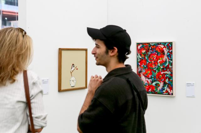 Visitors look at a painting at the 2024 Young Ho Nam Win-Win Cooperation the Grand Festival of Harmony Young Ho Nam Young Artist Art Exhibition Gwanghwamun Square in Seoul on June 24 2024 AJU PRESS Kim Dong-woo