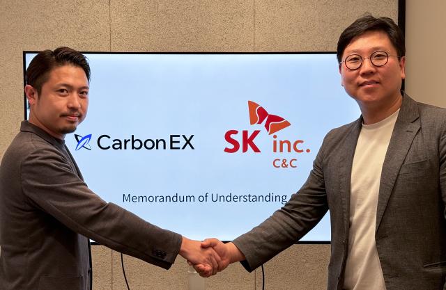 SK CCs Carbon Business Development Team Leader Park Sung-tae right and CarbonEXs COO Takayuki Kageyama pose for a photo after signing the MOU on carbon neutrality and carbon credit trading cooperation at Carbon X headquarters in Tokyo June 25 2024