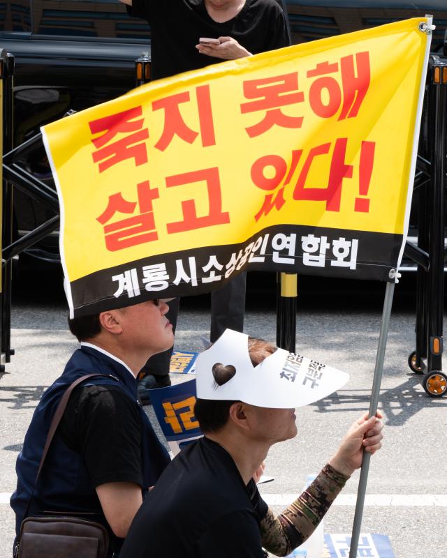 Protester holds flag reading Living because I cant die at minimum wage reform rally National Assembly Seoul June 25 2024 AJU PRESS Park Jong-hyeok