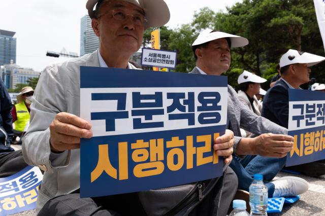 Protester displays placard calling for industry-specific minimum wages at reform rally National Assembly Seoul June 25 2024 AJU PRESS Park Jong-hyeok