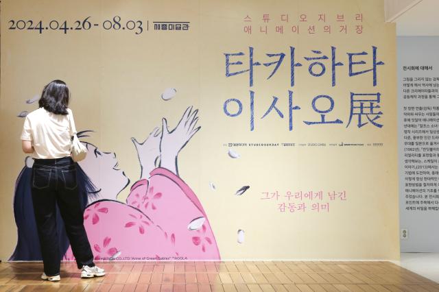 A visitor examines a poster on the wall at the entrance of the Studio Ghibli - Isao Takahata Exhibition held at the Sejong Center in Seoul on June 26 2024 AJU PRESS Han Jun-gu