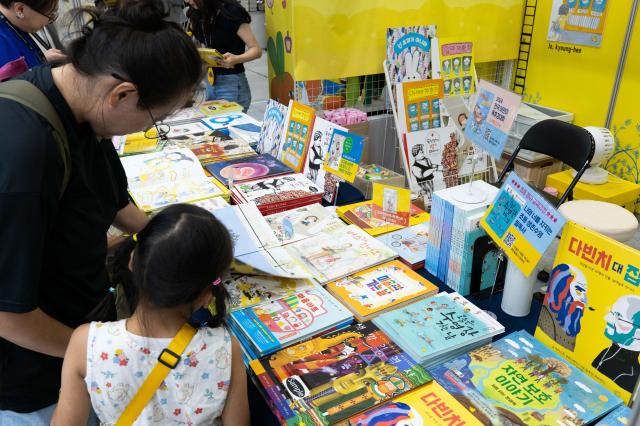 A family explores the children's book publishing section at the Seoul International Book Fair 2024, which will be held at COEX in Gangnam Seoul on June 26, 2024. AJU PRESS Park Jong-hyeok