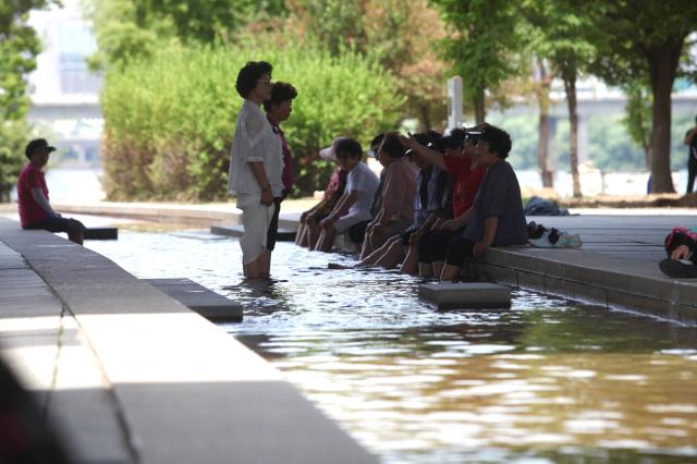 Visitors soak their feet in the flowing water at Yeouido Hangang Park in Seoul on June 27 2024 AJU PRESS Han Jun-gu