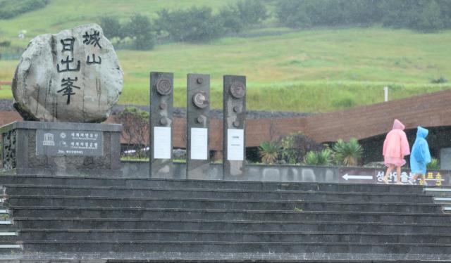 제주도에 호우주의보가 내려진 지난 27일 우비를 쓴 관광객들이 서귀포시 성산읍 성산일출봉을 탐방하고 있다 사진연합뉴스