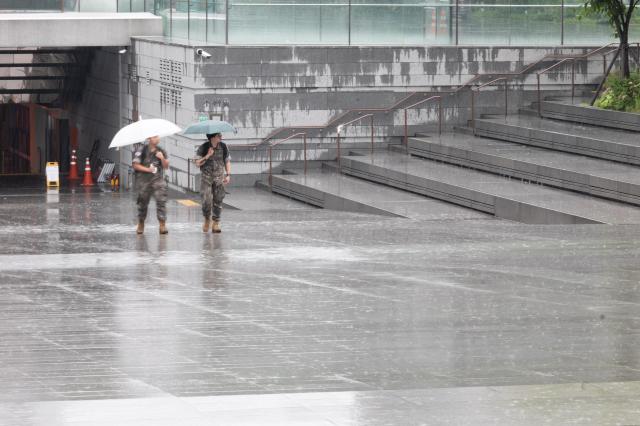 Military personnel hurry through heavy rain at Gwanghwamun Square in central Seoul on July 2 2024 AJU PRESS Park Jong-hyeok