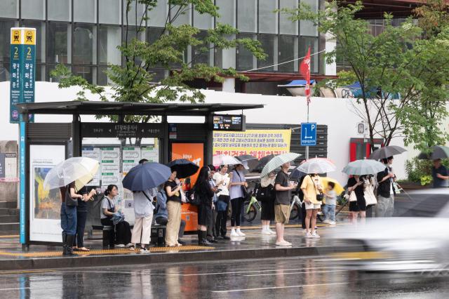 Citizens endure heavy rain while waiting for buses outside Exit 2 of Gwanghwamun Station in central Seoul on July 2 2024 AJU PRESS Park Jong-hyeok