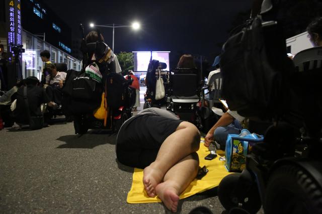 A protester lies on a cloth spread on the ground during the Move Toward Parade organized by SADD in front of the National Assembly on July 1 2024 AJU PRESS Han Jun-gu