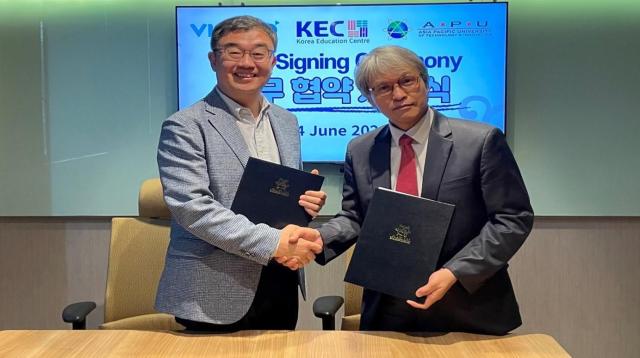 Visang Educations global business division head Paul Rho left and  and professor Seo Kyu-won of the Korean Language Education Centre at Asia Pacific University of Technology  Innovation pose after the signing of the agreement Courtesy of Visang Education