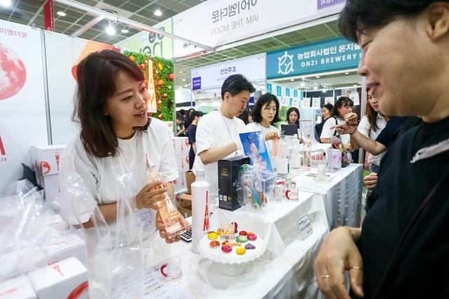 A booth representative introduces a wine at Seoul International Wine  Spirits Expo at COEX in Seoul on July 4 2024 AJU PRESS Kim Dong-woo