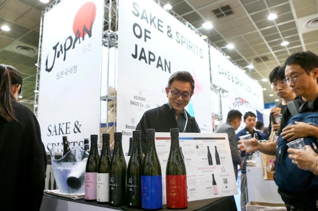 A booth representative introduces a sake at Seoul International Wine  Spirits Expo at COEX in Seoul on July 4 2024 AJU PRESS Kim Dong-woo