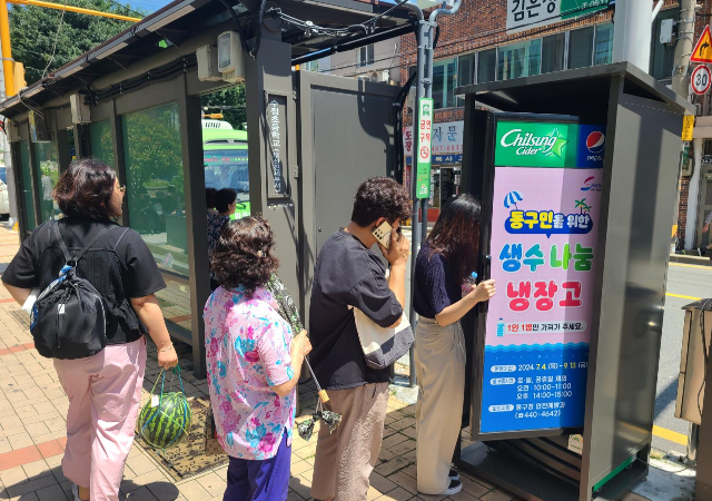 부산 동구에서 설치한 동구민을 위한 생수 나눔 냉장고 앞에서 주민들이 시원한 생수를 받기 위해 줄을 서고 있다사진부산동구