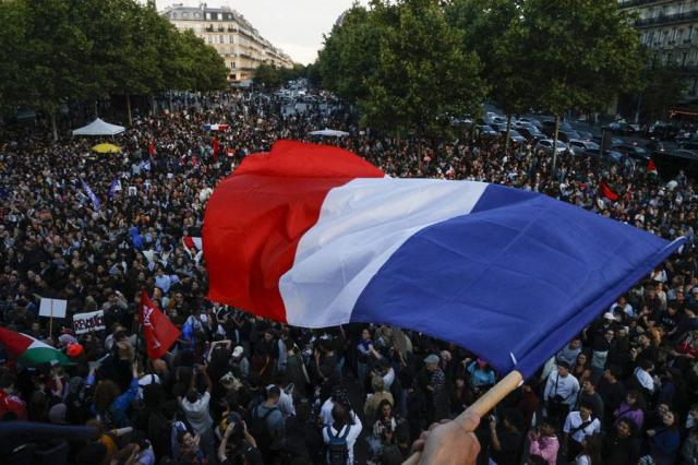 A protester hold a French flag as people gather at the Place de la Republique after partial results in the second round of the early French parliamentary elections in Paris France on July 7 2024 Reuters-Yonhap