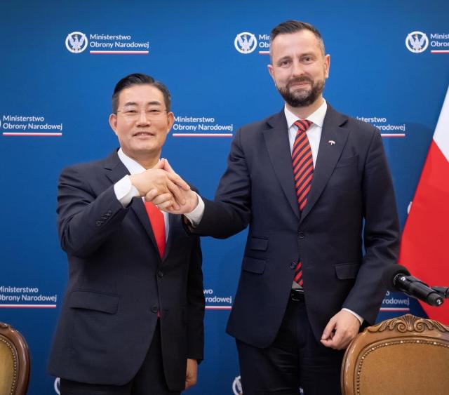 Defense Minister Shin Won-sik left is shaking hands and making a handprint with Polish Defense Minister Kosiniak-Kamysz in Poland on June 20 Courtesy of the Ministry of National Defense