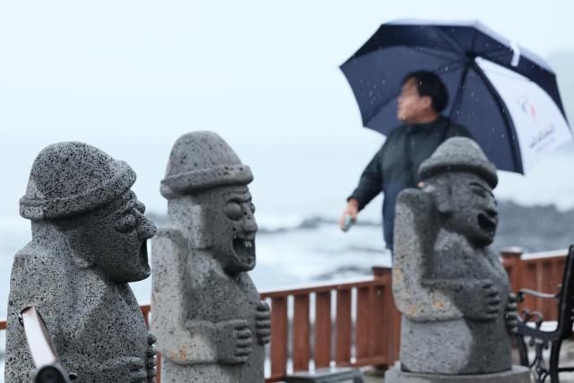 한 시민이 10일 오전 비가 내리는 가운데 제주 서귀포시 대정읍 사계해안로를 걷고 있다 사진연합뉴스